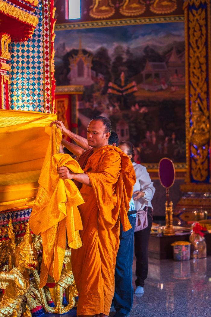 พระสงฆ์กำลังประกอบพิธีห่มผ้าถวายเป็นพุทธบูชา